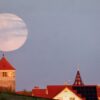 Während der Römerturm in Emerkingen von der Abendsonne angestrahlt wird, geht hinter ihm der Vollmond auf.