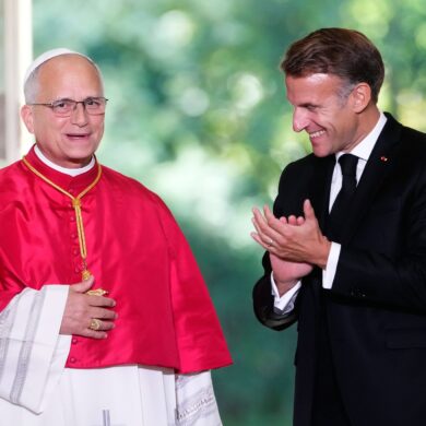 Frankreichs Präsident Emmanuel Macron beklatscht den Gast aus dem Vatikan.