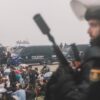 Migranten wurden in Ceuta von starken spanischen Polizeikräften von einem Hüttenlager am Strand fortgebracht.