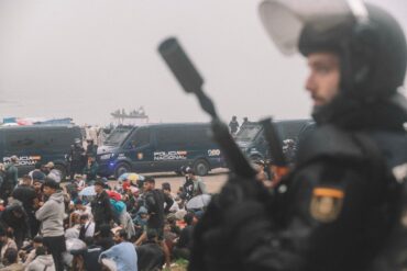 Migranten wurden in Ceuta von starken spanischen Polizeikräften von einem Hüttenlager am Strand fortgebracht.
