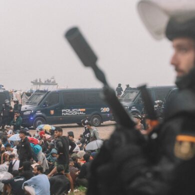 Migranten wurden in Ceuta von starken spanischen Polizeikräften von einem Hüttenlager am Strand fortgebracht.