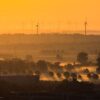 Windräder und Nebel zeichnen sich im Licht der aufgehenden Sonne in der Region Hannover ab.