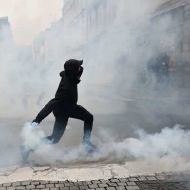 Ein Demonstrant wirft in Rennes eine Tränengasgranate in Richtung der Polizei.