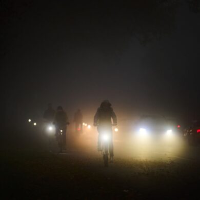 Rad- und Autofahrer fahren am frühen Morgen im Nebel über den Osterdeich.