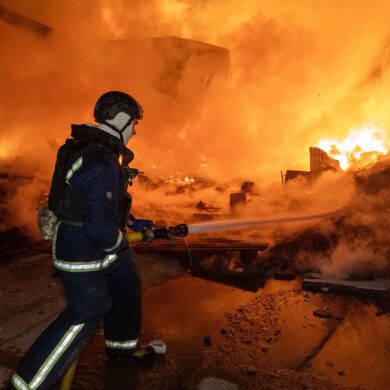 Vor den Flammen: Ein Feuerwehrmann löscht nach dem russischen Luftangriff einen Brand in einem Wohngebiet.