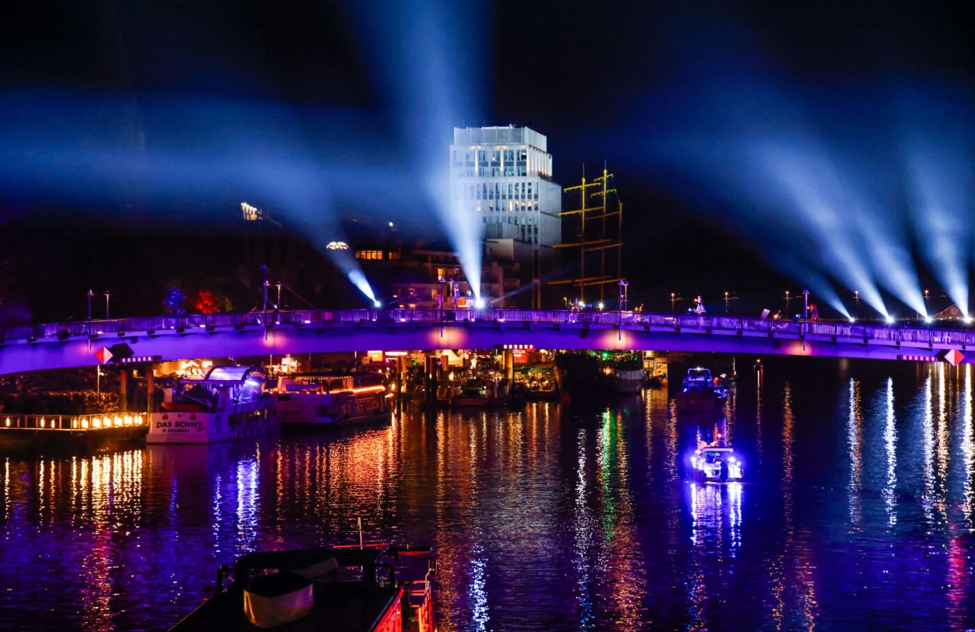 Beleuchtete Boote und Schiffe fahren am Tag der Deutschen Einheit bei einer abendlichen Lichtshow auf der Weser in Bremen.