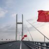 Chinesische Fahnen wehen auf einer Brücke.